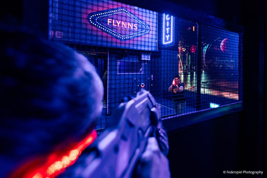 Player engaging in laser tag at Muri near Bern in front of 'Flynn's Arcade