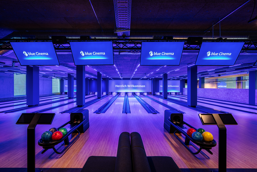 Modern bowling lanes in blue Cinema with dynamic lighting.