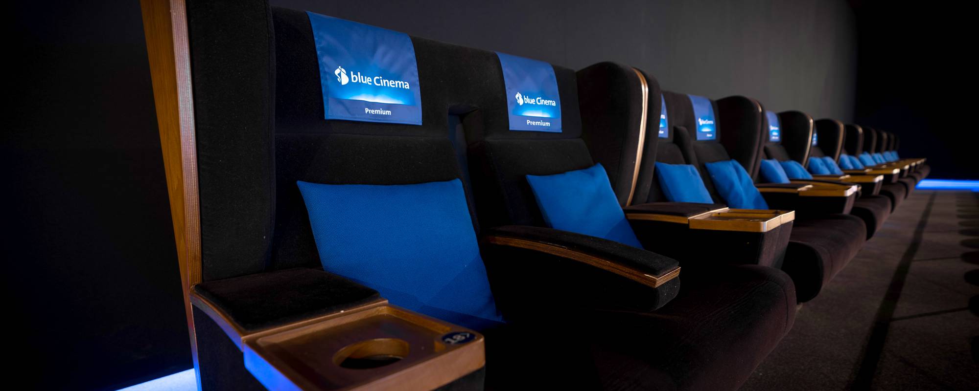 Sièges de cinéma premium de blue Cinema avec des accents bleus pour une expérience de visionnage exclusive.