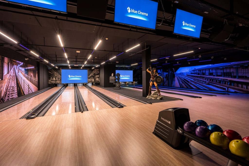 Modern bowling lanes in blue Cinema with dynamic lighting.