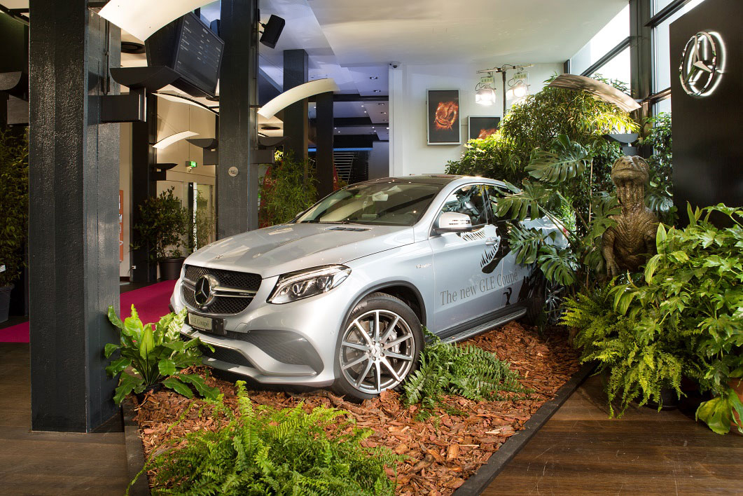 Ein neuer Mercedes GLE Coupé ausgestellt im Kinofoyer, umgeben von einer Dschungeldekoration.