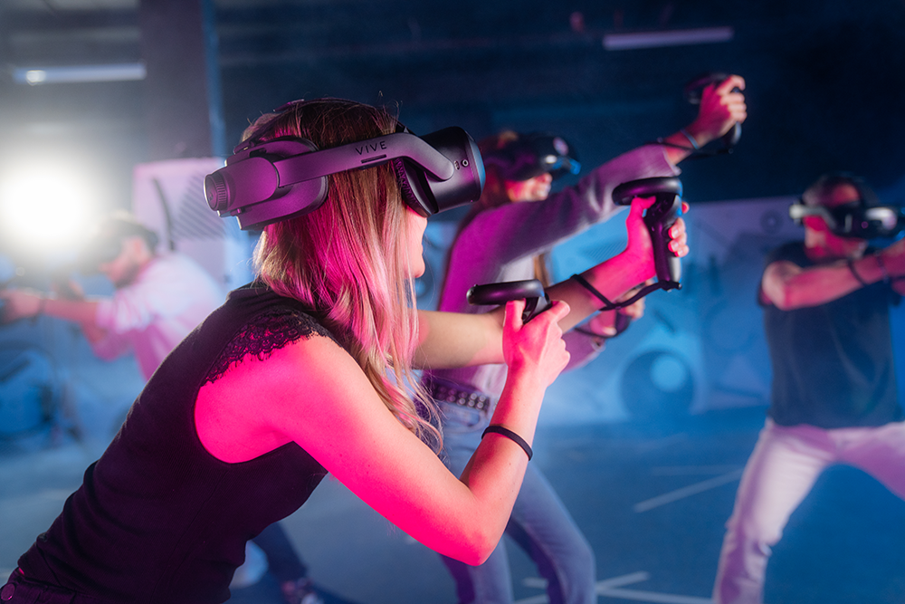 Des personnes dans une arène de jeu en réalité virtuelle vivant une aventure interactive ensemble.